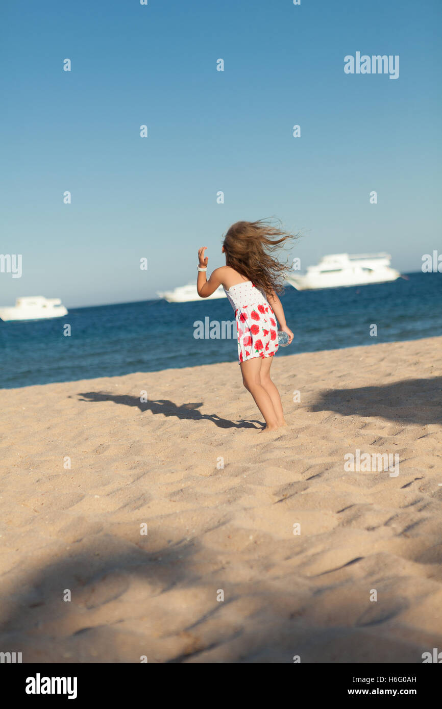 hübsches junges Mädchen suchen im gelben Meeressand Stockfoto