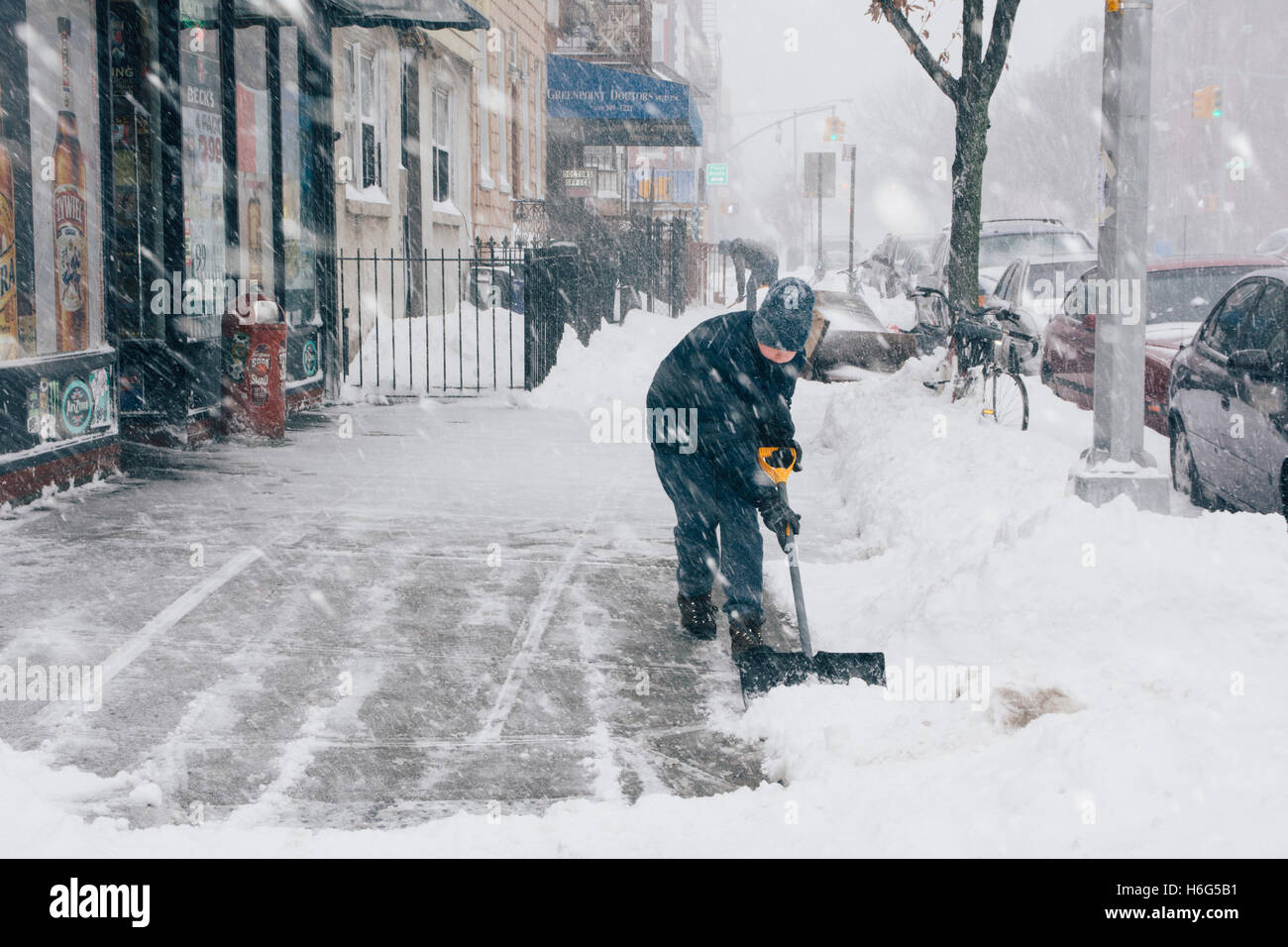 Junge Schaufeln Bürgersteig während Schneesturm. Brooklyn. New York City/USA Stockfoto