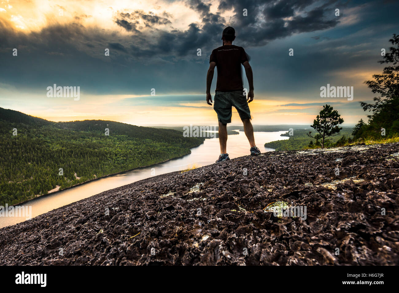 Dramatische Schuss von einem jungen Mann auf einem Berg mit Blick auf im Acadia National Park, Mount Desert Island, Maine. Stockfoto
