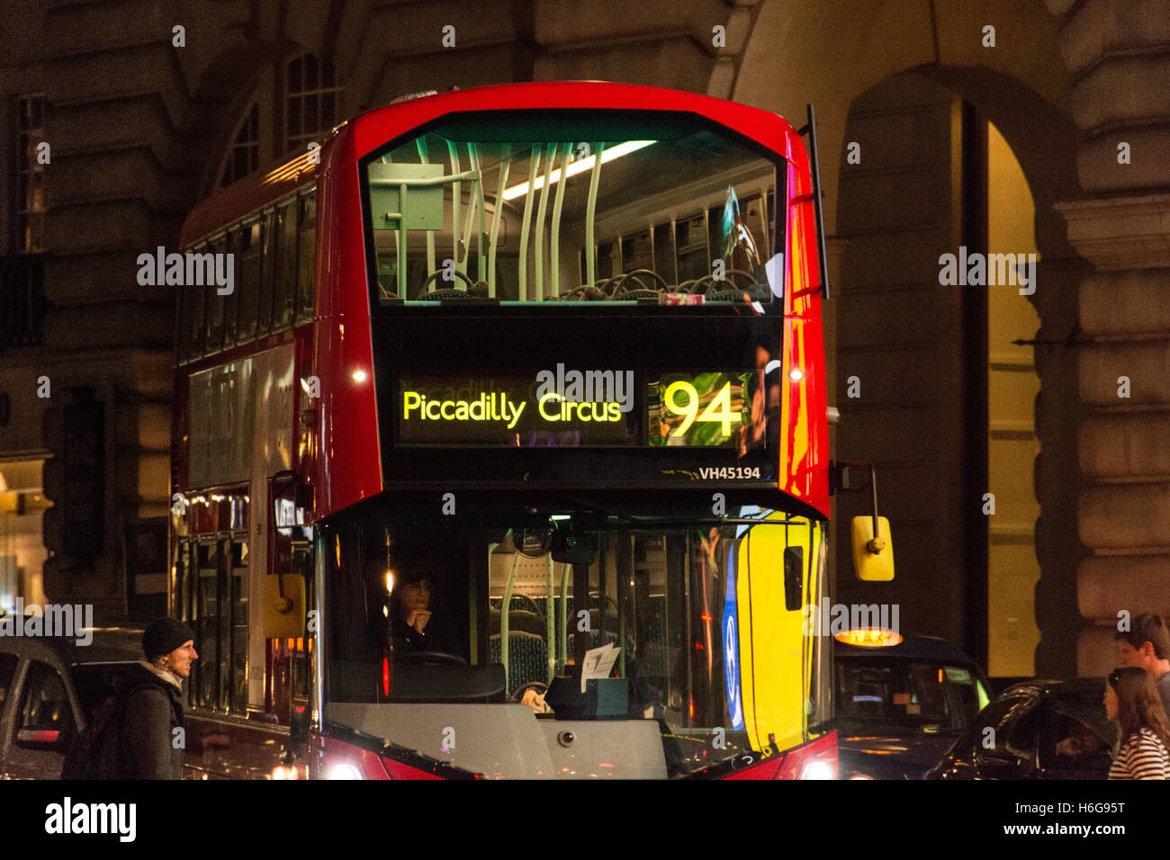 Ein Nachtbus fährt durch einen hell erleuchteten und beleuchteten Piccadilly Circus im Zentrum von London, Großbritannien Stockfoto