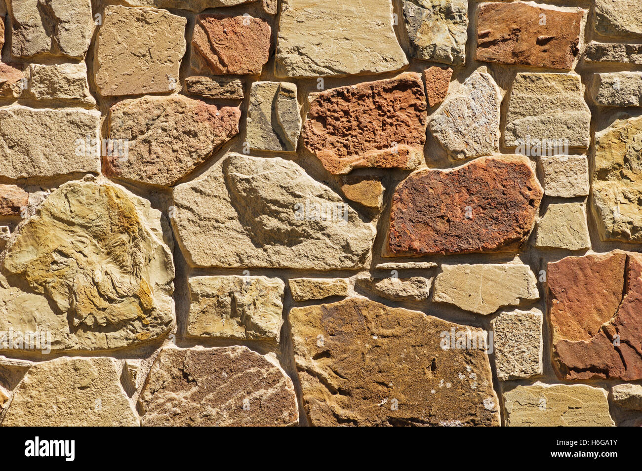 Tan und rötliche Steinmauer Hintergrundtextur Stockfoto