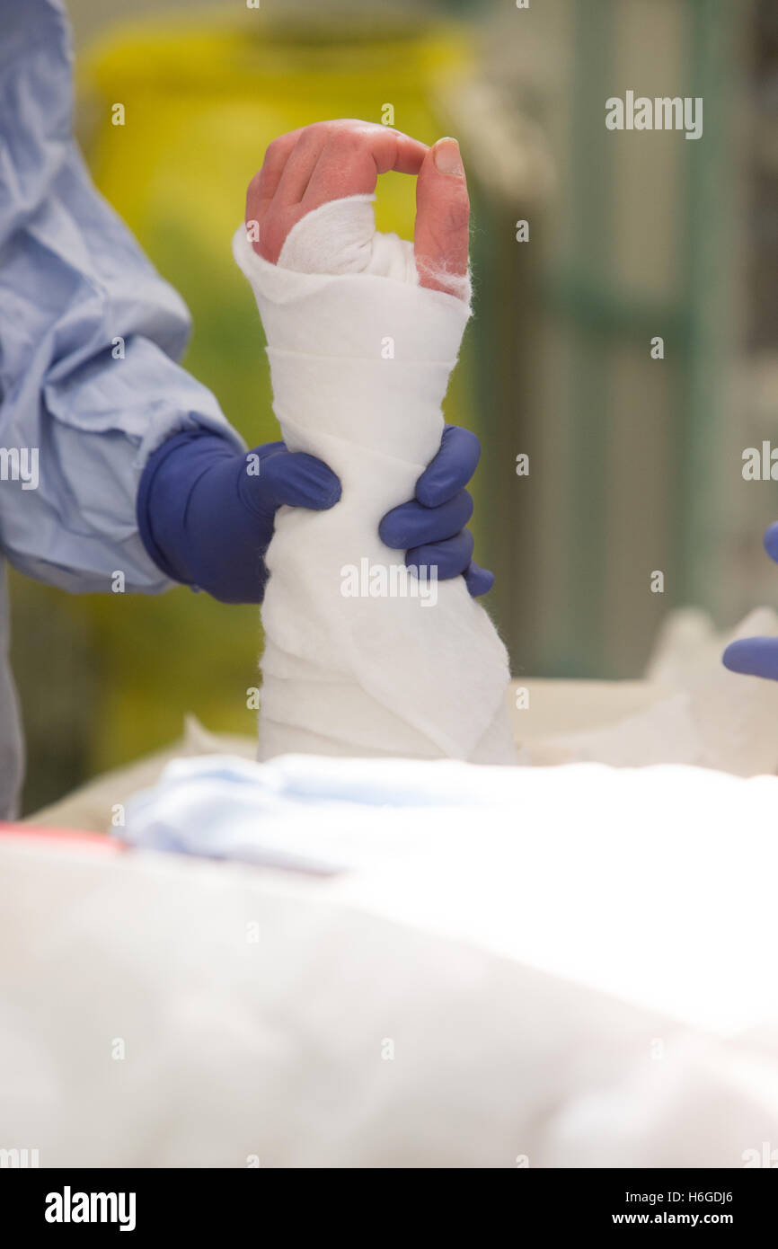 Krankenschwester hält bandagierte Hand eines Patienten während einer operation Stockfoto
