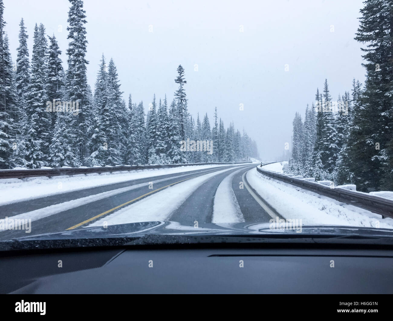 Sicht des Fahrers Aussichtspunkt durch Windschutzscheibe leer verschneiten Straße im Winter fahren Stockfoto