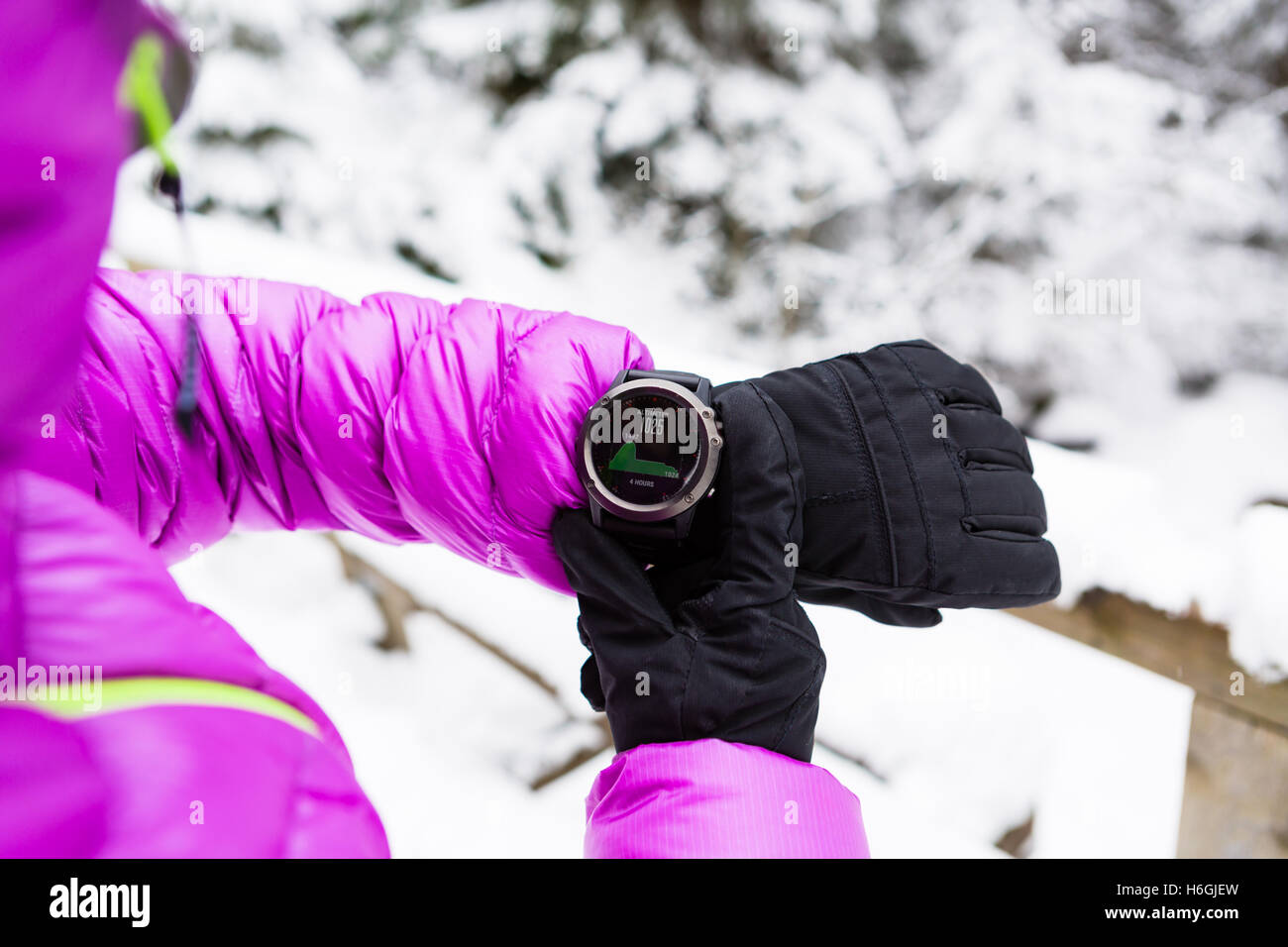 Frau Wanderer überprüfen die Erhebung auf Sportuhr, Smartwatch mit Höhenmesser app im Winter Wälder und Berge. Weibliche trekker Stockfoto