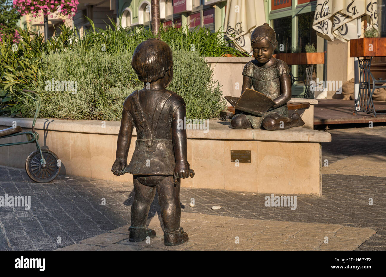 Spielende Kinder, Bronze-Skulptur erstellt von Rita Soros und Eva Szabo in 2010 auf Ady Endre Utca in Kaposvar, Ungarn Stockfoto