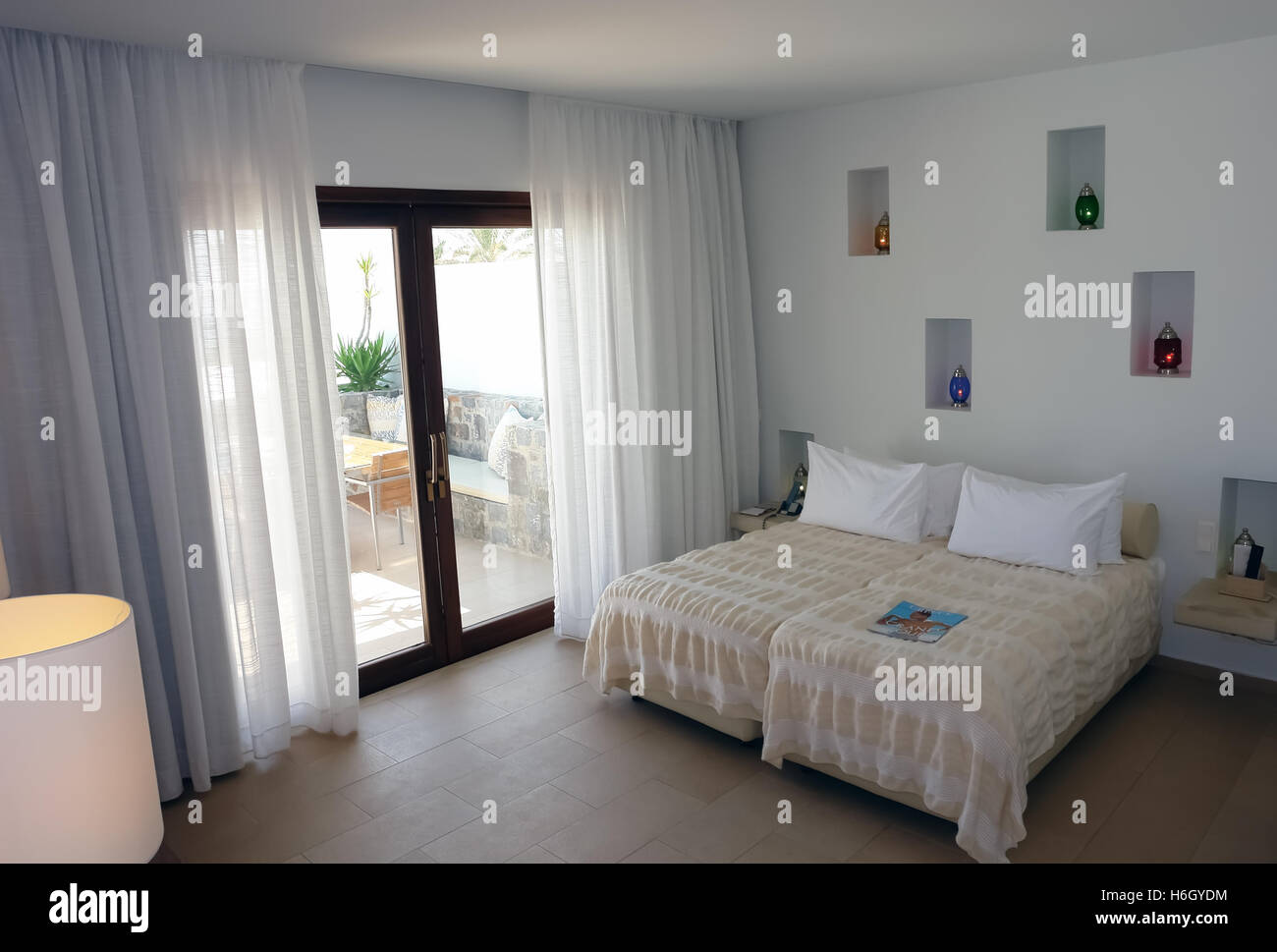 HERAKLION, Kreta, Griechenland - 13. Mai 2014: Innenliegendes Zimmer mit großem Bett, Farbe Lampen und Terrasse in modernen Gebäude des Luxushotels Stockfoto