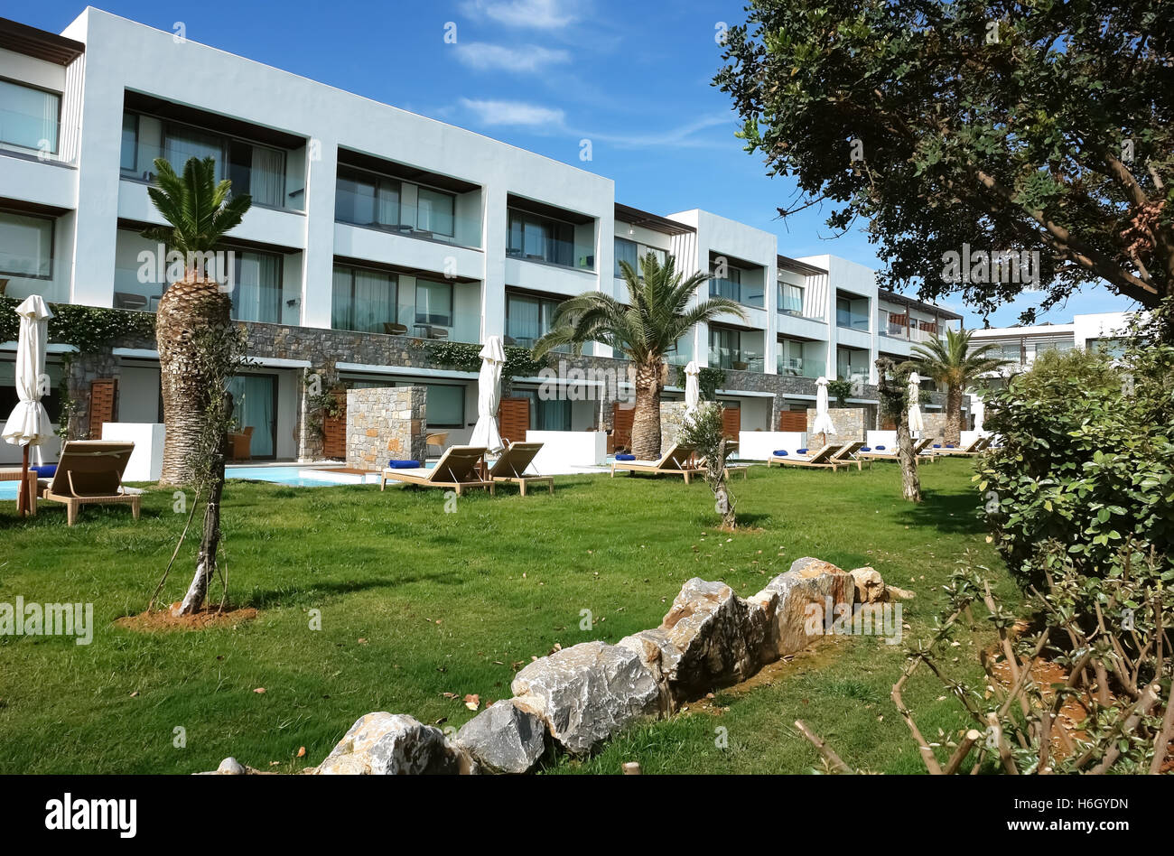 HERAKLION, Kreta, Griechenland - 13. Mai 2014: Blauer Himmel, modernes Gebäude Villa mit Balkon und Palmen am Gelände des Luxushotels. Stockfoto