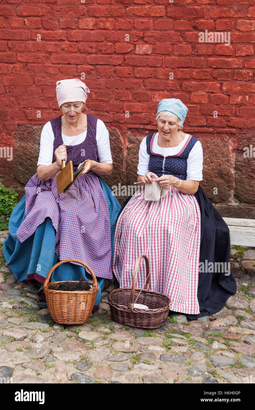 Zwei Damen gekleidet in traditioneller Tracht kardieren und stricken, Den Gamle By, Aarhus (Dänemark) Stockfoto