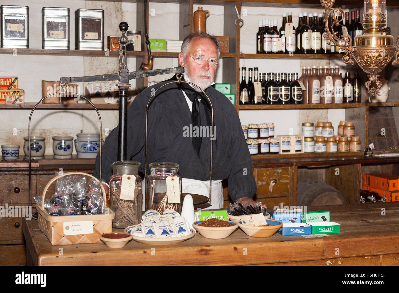 Ein Ladenbesitzer in einem Shop, Den Gamle By, Aarhus, Dänemark Stockfoto