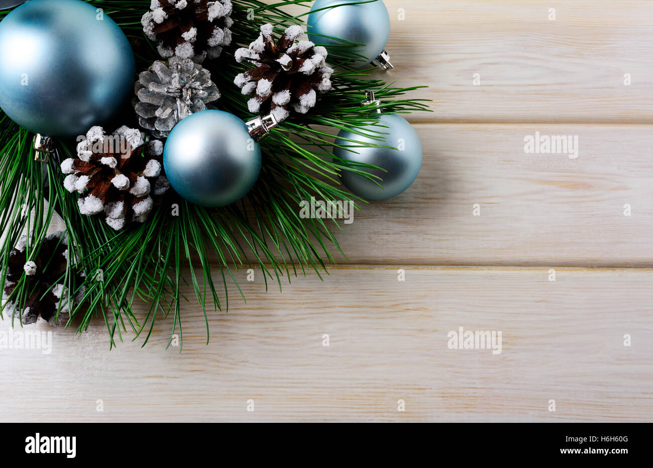 Weihnachten Hintergrund mit blauen Ornamenten und verschneiten Tannenzapfen. Weihnachts-Party-Dekoration mit glänzenden Kugeln. Kopieren Sie Raum. Stockfoto