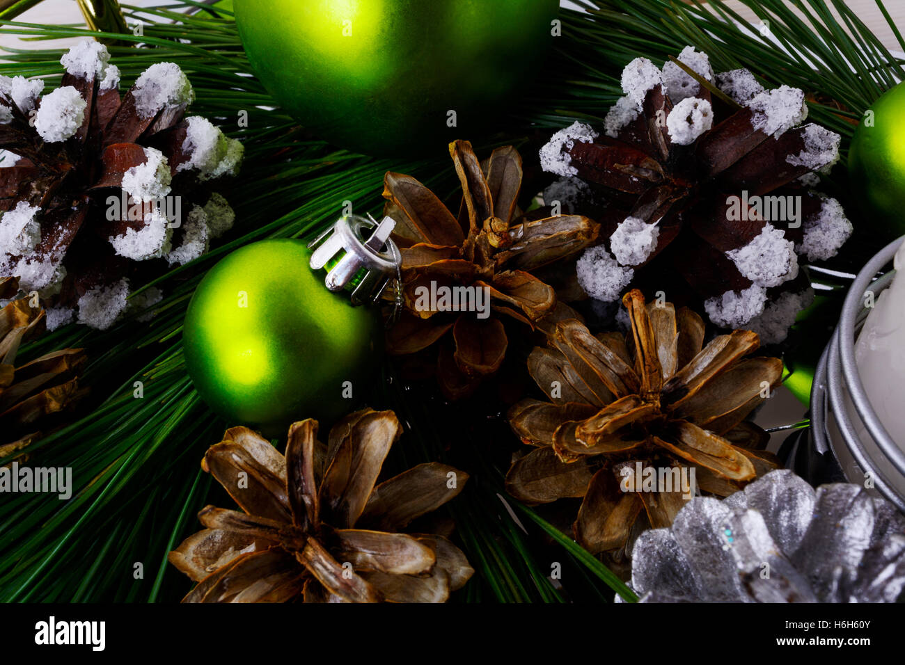 Weihnachten Hintergrund mit verschneiten Tannenzapfen und grüne Ornamente. Weihnachts-Party-Dekoration mit glänzenden Kugeln. Stockfoto