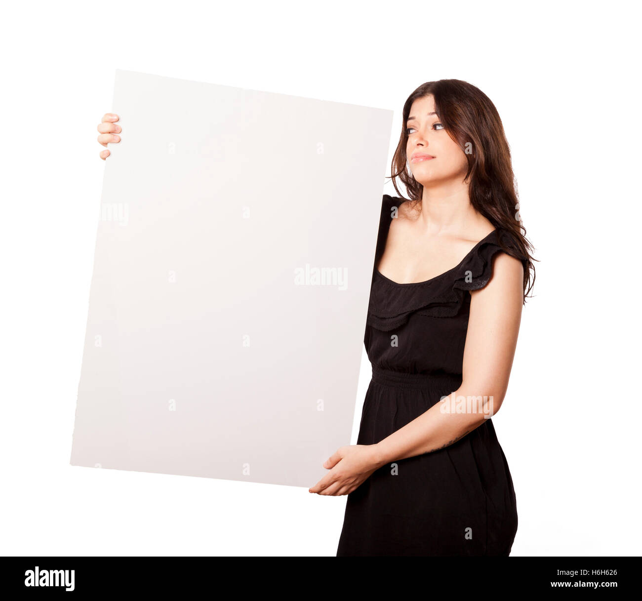 Schöne junge Erwachsene kaukasischen Frau in ihrer Mitte 20 mit Blick auf das leere weiße Zeichen, die sie mit beiden Händen hält. Isoliert auf Stockfoto
