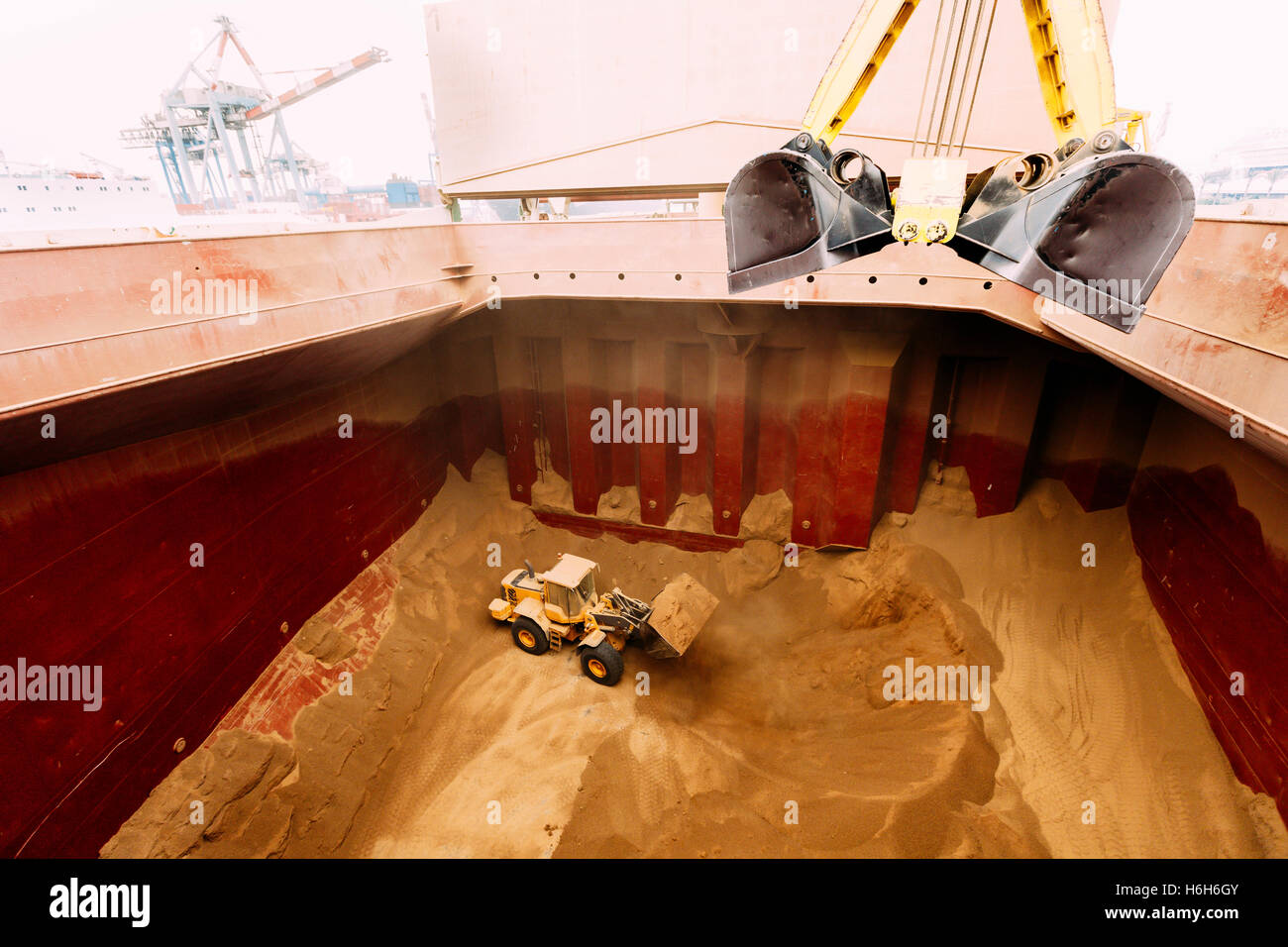 Ein Bagger, Vermittlung von Gluten in der Grube ein Korn-Frachter Schiff für einen leichteren Zugang für die Maschinen, die Emptyi sind Stockfoto