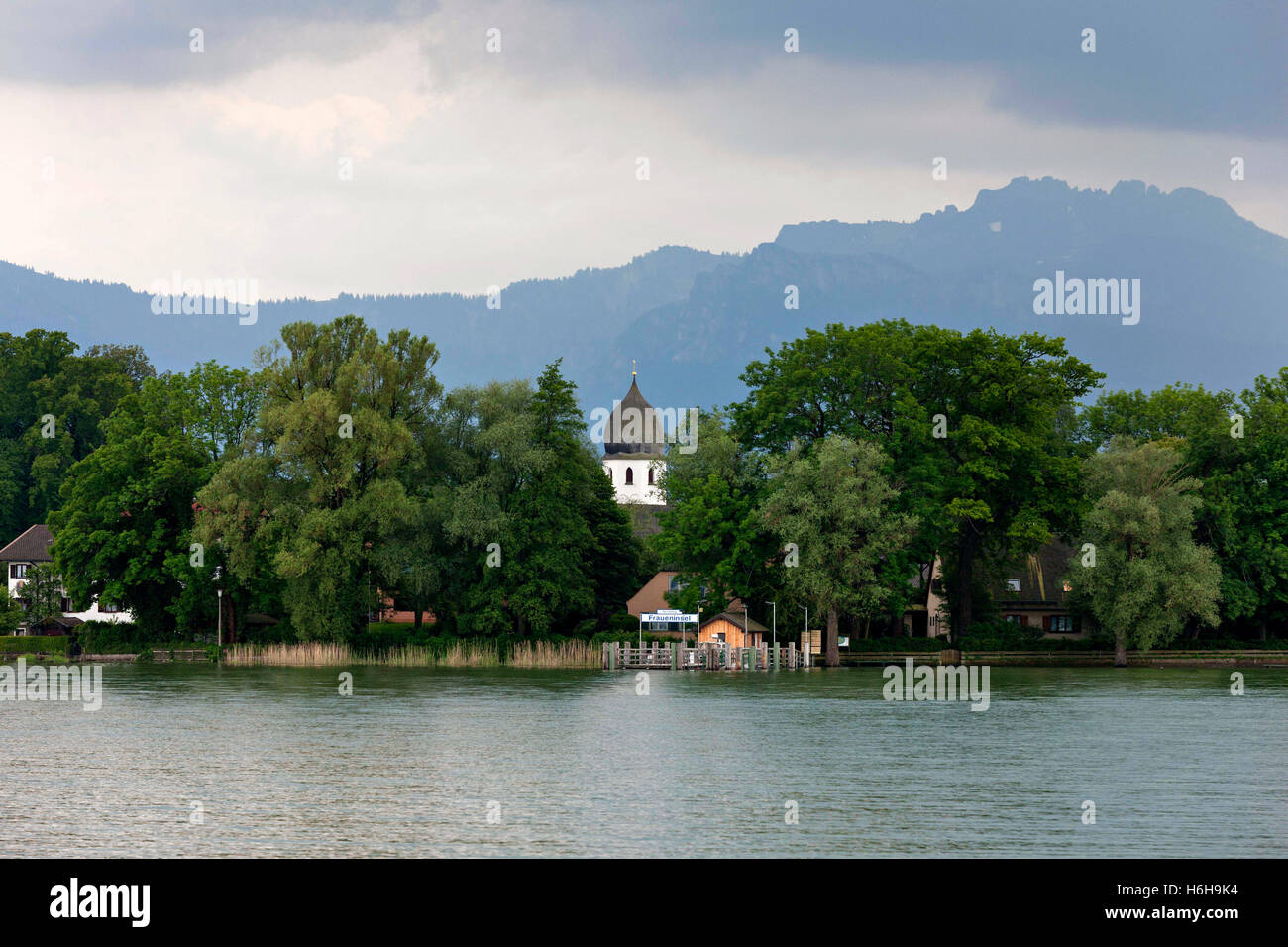 Blick auf die Fraueninsel (Insel) und die Klosterkirche mit der Kampenwand im Hintergrund, Chiemsee Chiemgau, Bayern Stockfoto