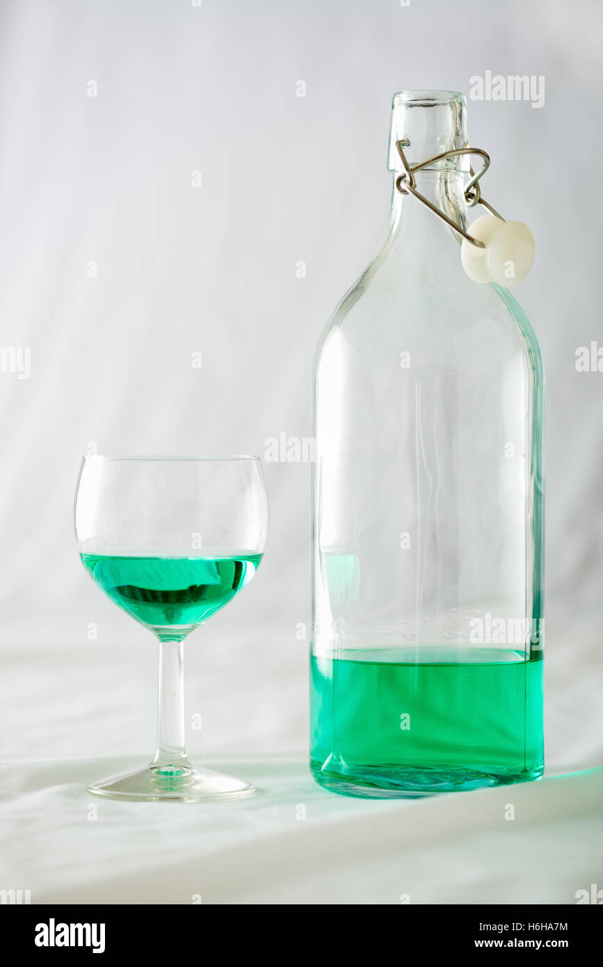 Ein Glas und Flasche Absinth setzen auf weißem Hintergrund Stockfoto