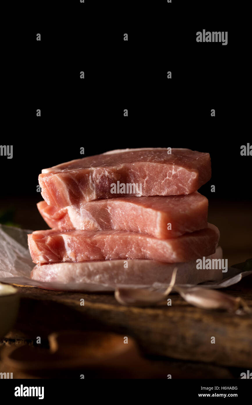 Rohe Schweinerippchen fertig um zu kochen. Im gedämpften Licht gedreht. Mit Textfreiraum Stockfoto