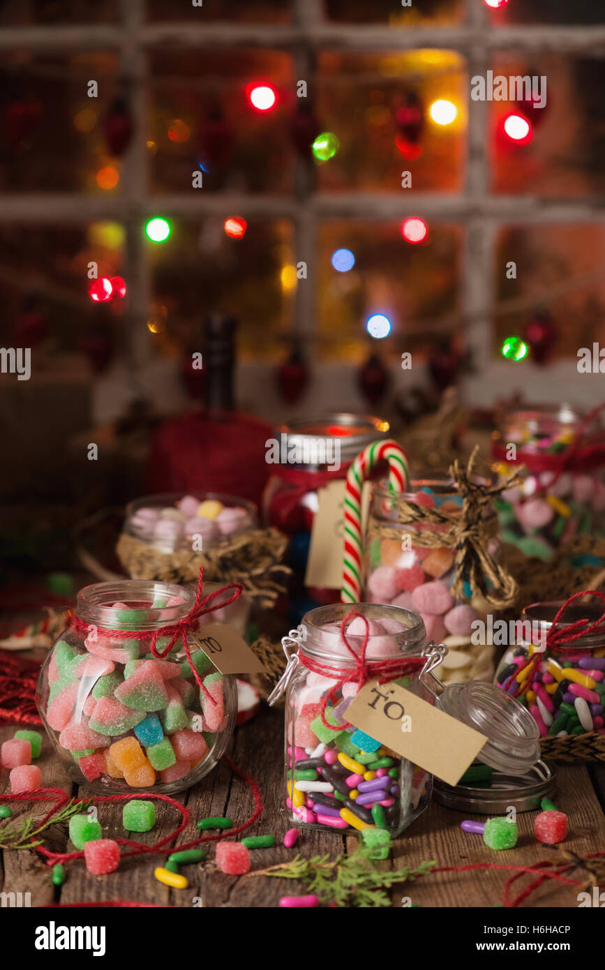 Verschiedene Süßigkeiten in Gläsern für Weihnachtsgeschenke auf rustikalen Holztisch Stockfoto
