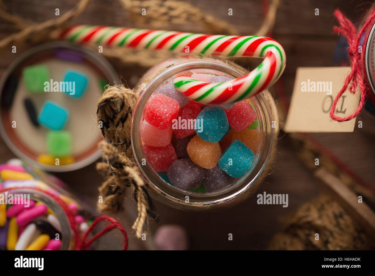 Verschiedene Süßigkeiten in Gläsern für Weihnachtsgeschenke auf rustikalen Holztisch Stockfoto