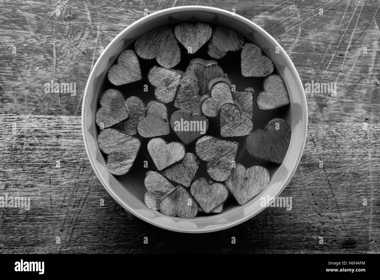 Holz Herzen schweben in Schüssel mit Wasser. Könnte für den Valentinstag verwendet werden. In schwarz und weiß. Stockfoto