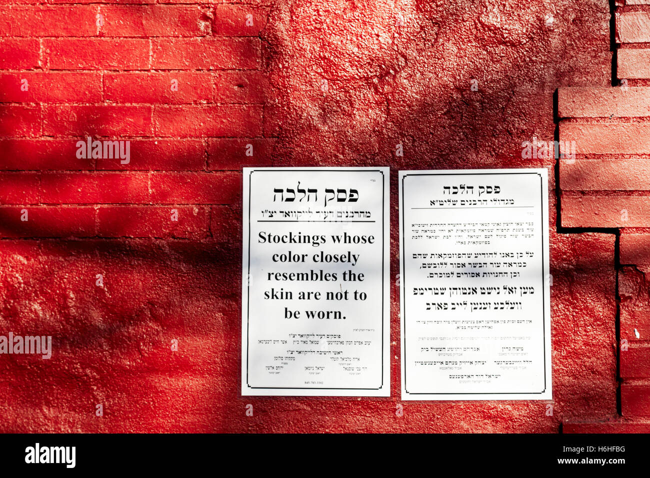 New-York - 14 NOV: Eine Benachrichtigung auf eine rote Wand informieren in Jiddisch und Englisch in Bezug auf eine jüdische Halacah Gesetz in New York, USA Stockfoto