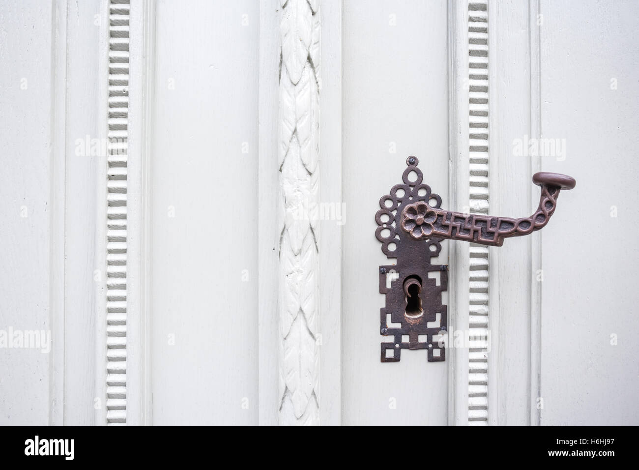 auf einer alten Tür ist ein Türgriff mit Tastensperre Stockfoto