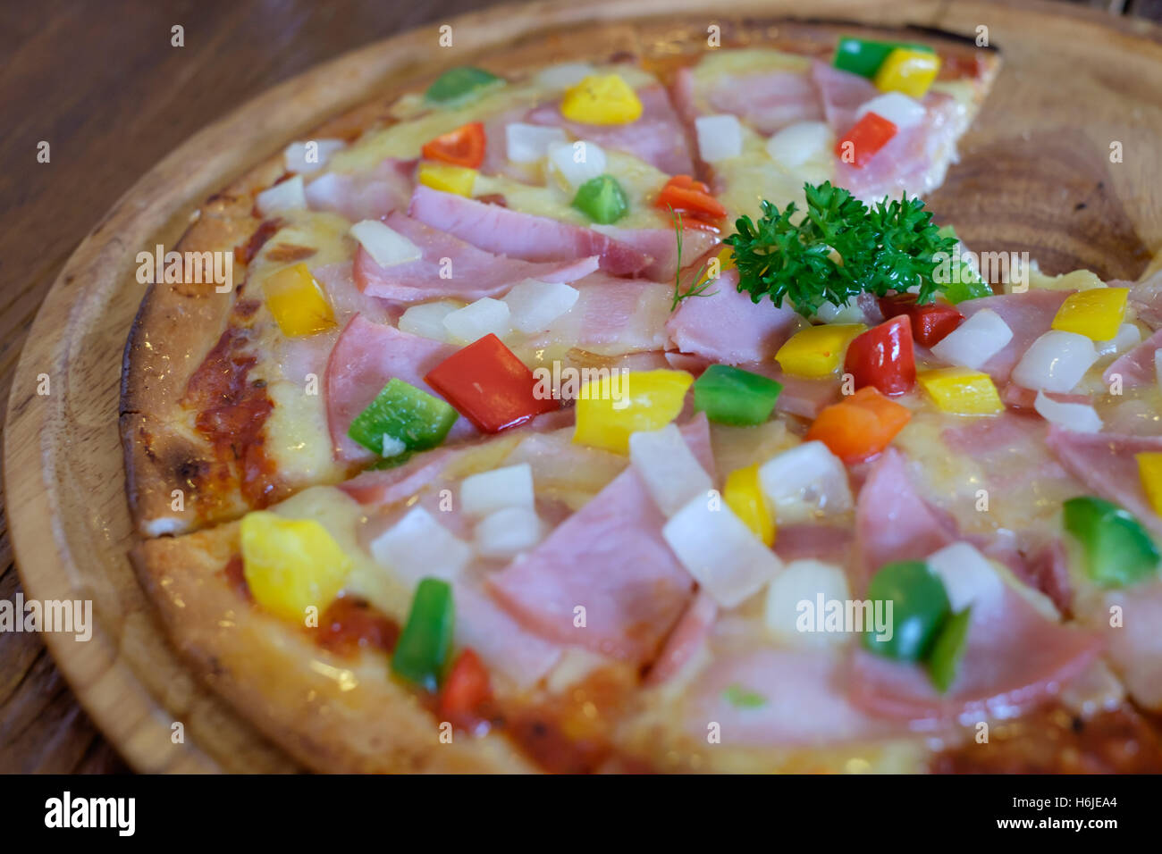 Nahaufnahme von Speck Schinken Pizza auf Holztablett im Restaurant. Stockfoto