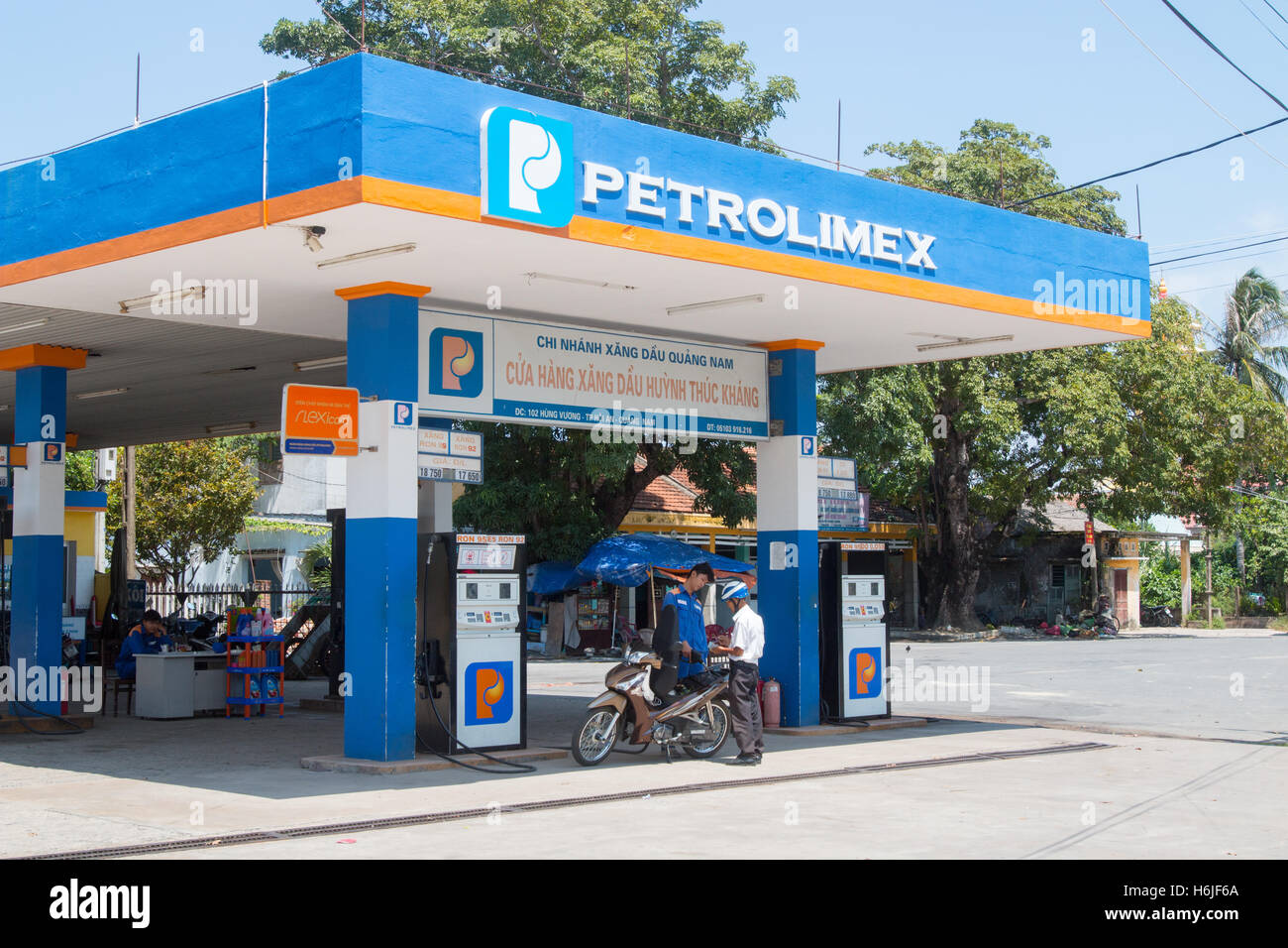 Attendant setzen Brenngas in Roller Motorrad bei einer vietnamesischen Tankstelle Petrolimex, Vietnam Stockfoto