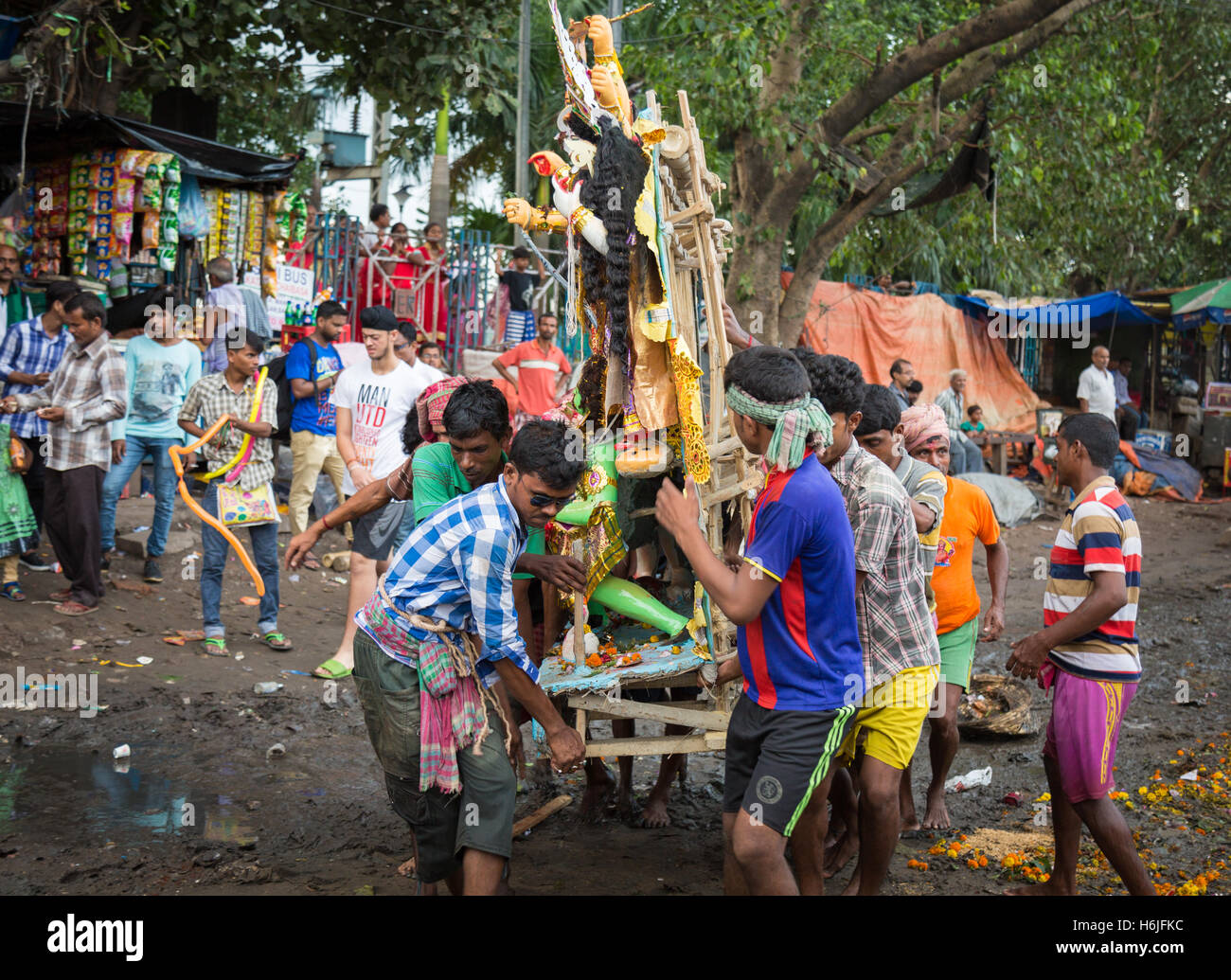 Gruppe von Männern tragen Durga Idol zum Fluss Ganges eintauchen in Babughat Kolkata, Westbengalen, Indien. Stockfoto