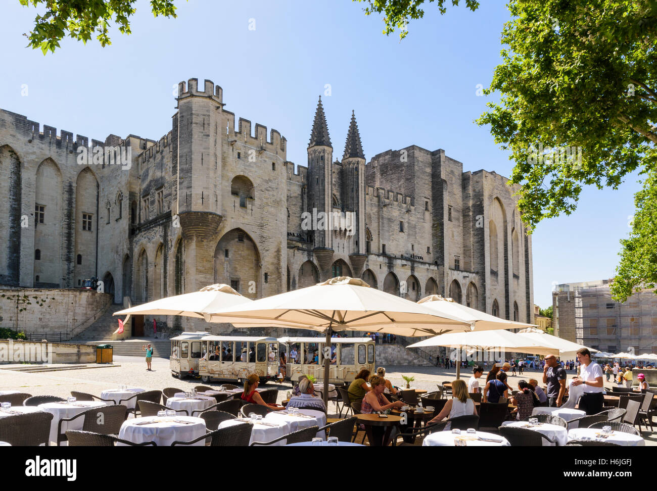Restaurant, überragt von der gotischen Twin zweitürmige Fassade des Palais Neuf, Palais des Papes, Schlossplatz, Avignon, Frankreich Stockfoto