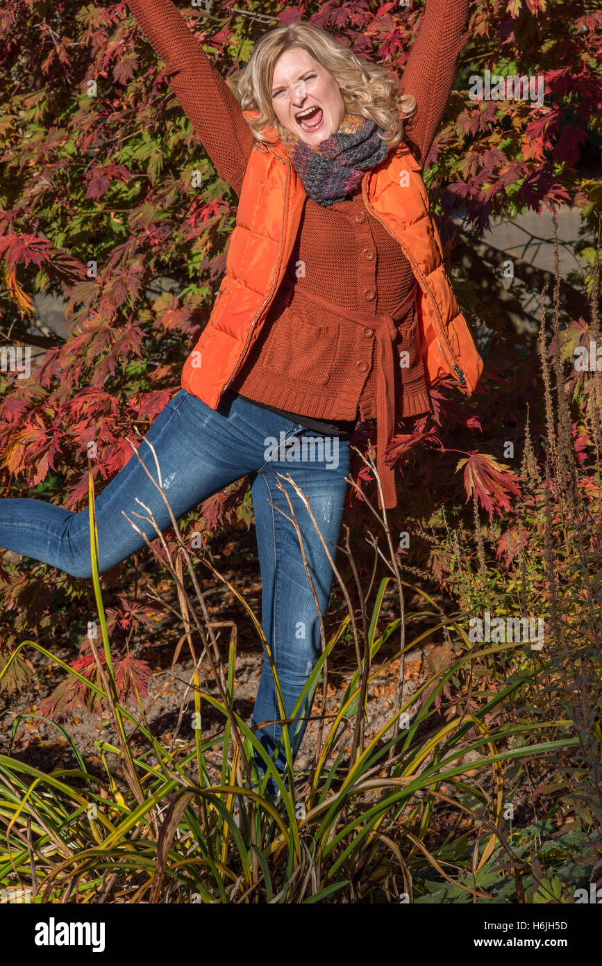 Attraktive blonde Frau im Park freut sich auf den Herbst Stockfoto