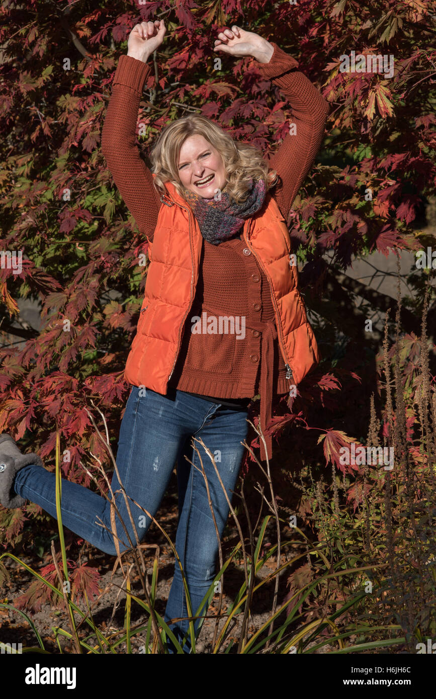 Attraktive blonde Frau im Park freut sich auf den Herbst Stockfoto