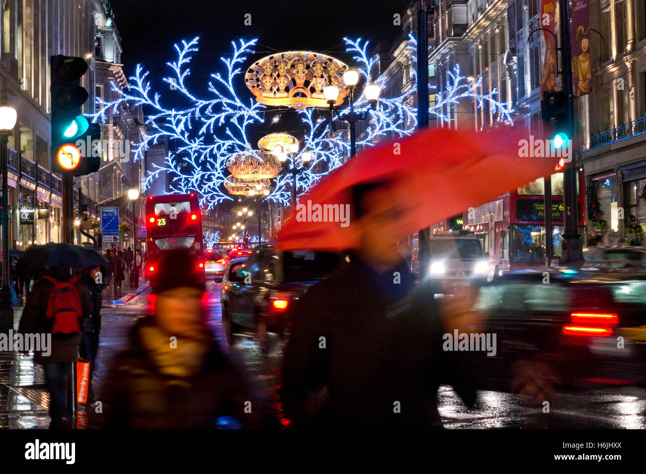Beschäftigt verschwommene Weihnachts-Einkäufer & Verkehr in Regen fegte Regent Street mit Weihnachtsbeleuchtung hinter London UK Stockfoto