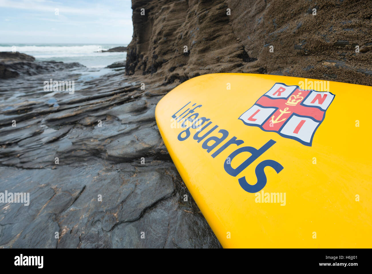 Rescue Board mit Label "Bademeister" von der Royal National Lifeboat Institution stützte sich auf einem Felsen am Trebarwith Strand, Westküste von Cornwall, UK Stockfoto
