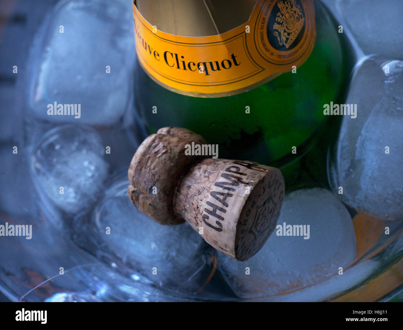 Schließen Sie die Ansicht auf Veuve Clicquot feine Flasche Champagner auf Eis im Weinkühler mit Champagner Korken in atmosphärischen niedrigen Lichtverhältnissen Stockfoto