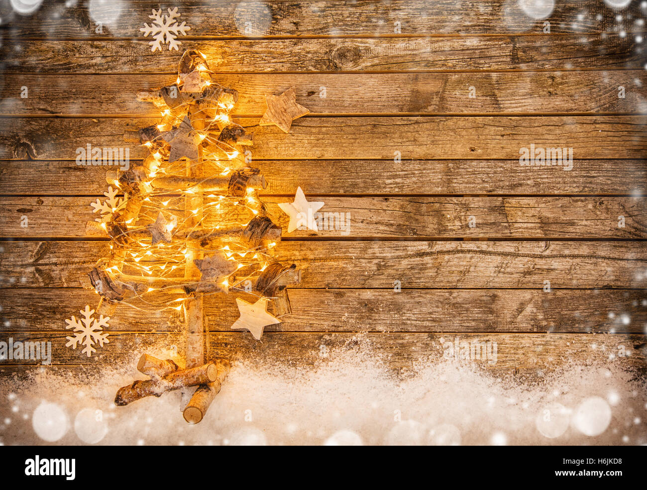 Weihnachtsbaum mit Schnee-Dekoration auf alten Holzdielen gelegt. Stockfoto