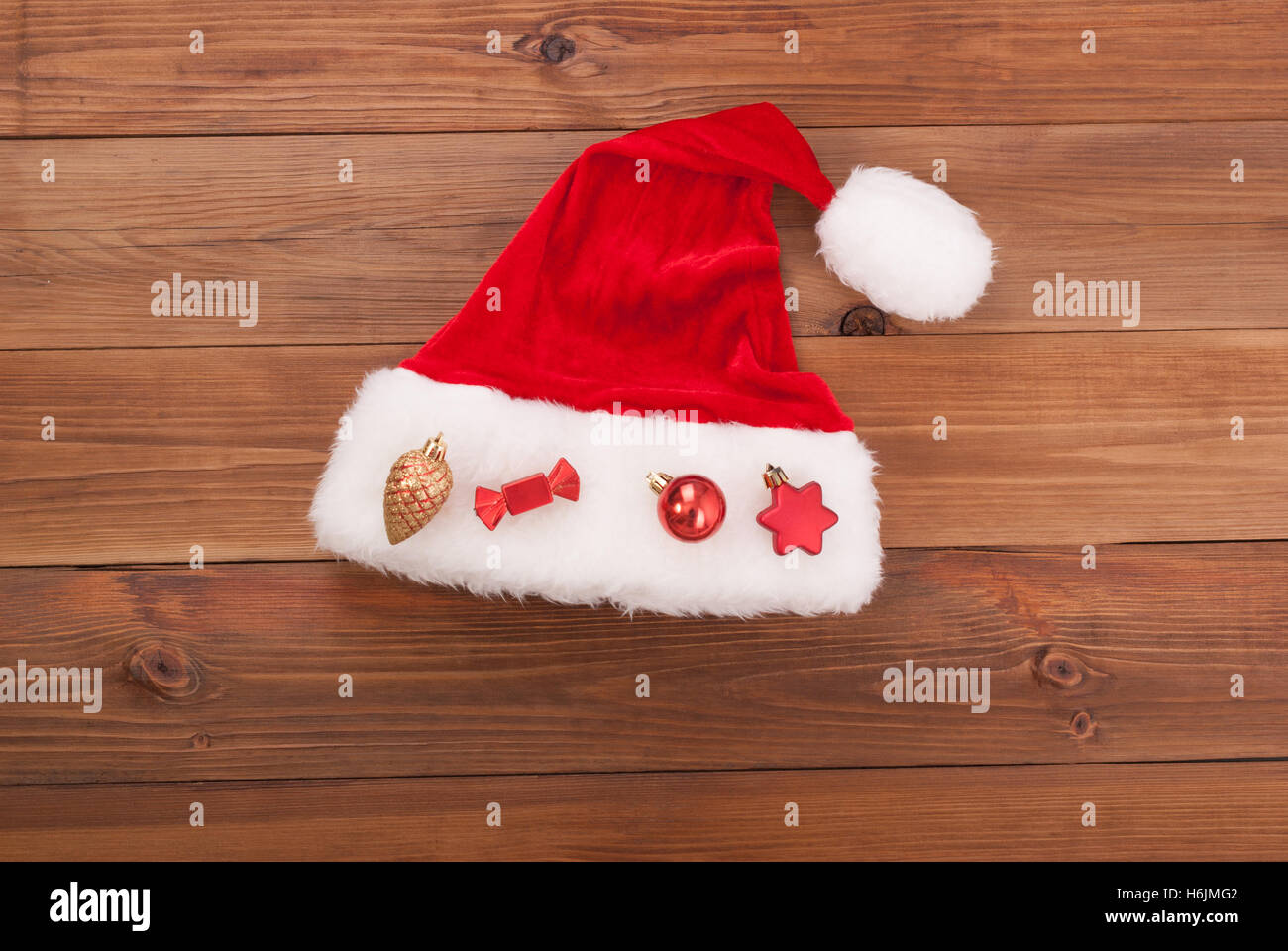 Weihnachtsmütze Claus mit Spielzeug auf hölzernen Hintergrund. Stockfoto