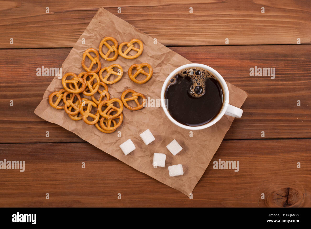 Tasse Kaffee und leckere Brezel auf einem hölzernen Hintergrund. Ansicht von oben. Stockfoto