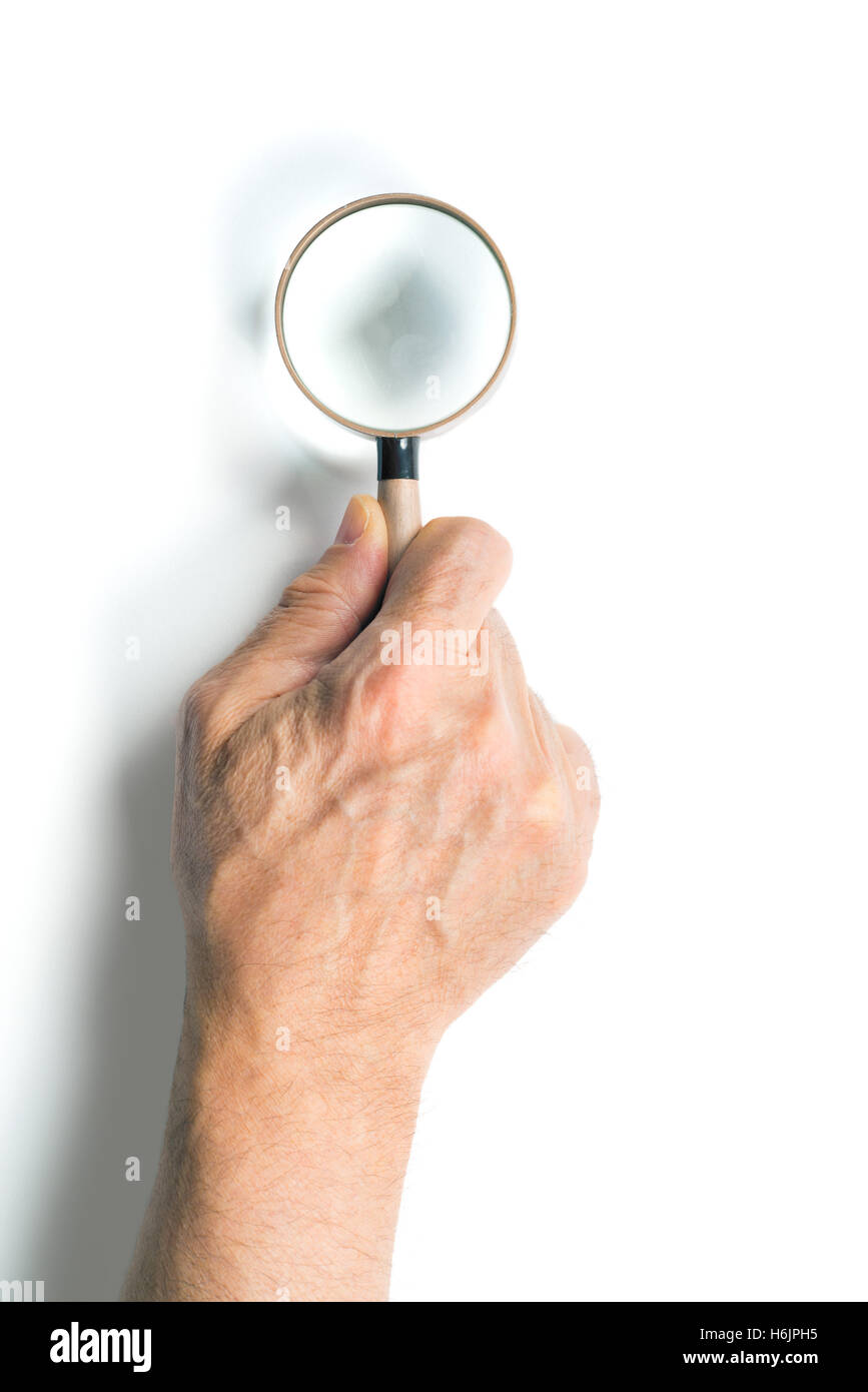 männliche Hand mit einer Lupe. isoliert auf weißem Hintergrund Stockfoto