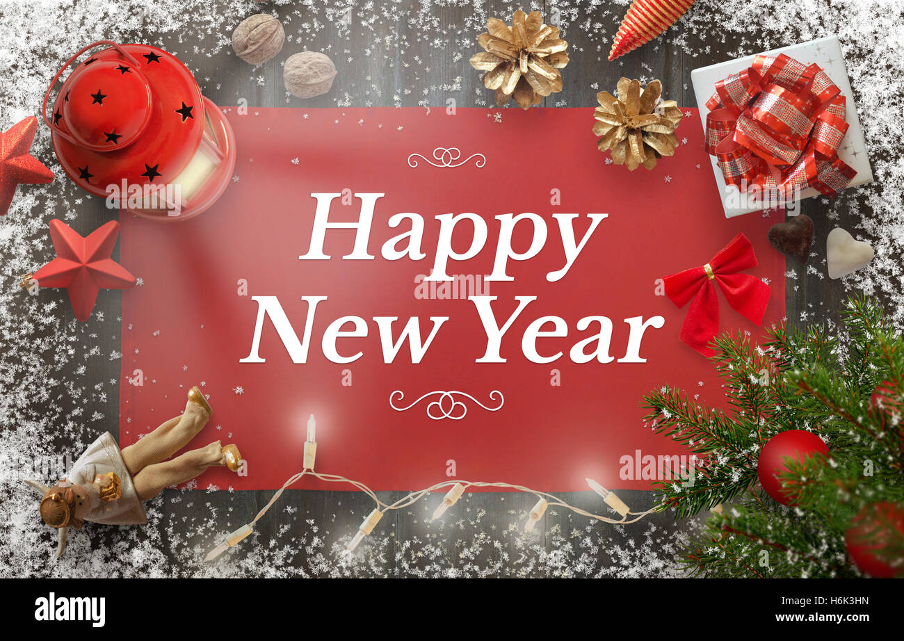 Glückliches Neujahr Gruß mit Weihnachtsbaum, Geschenk, Dekoration, Laterne, Tischdecke und Schneeflocken auf Holzbrett. Stockfoto