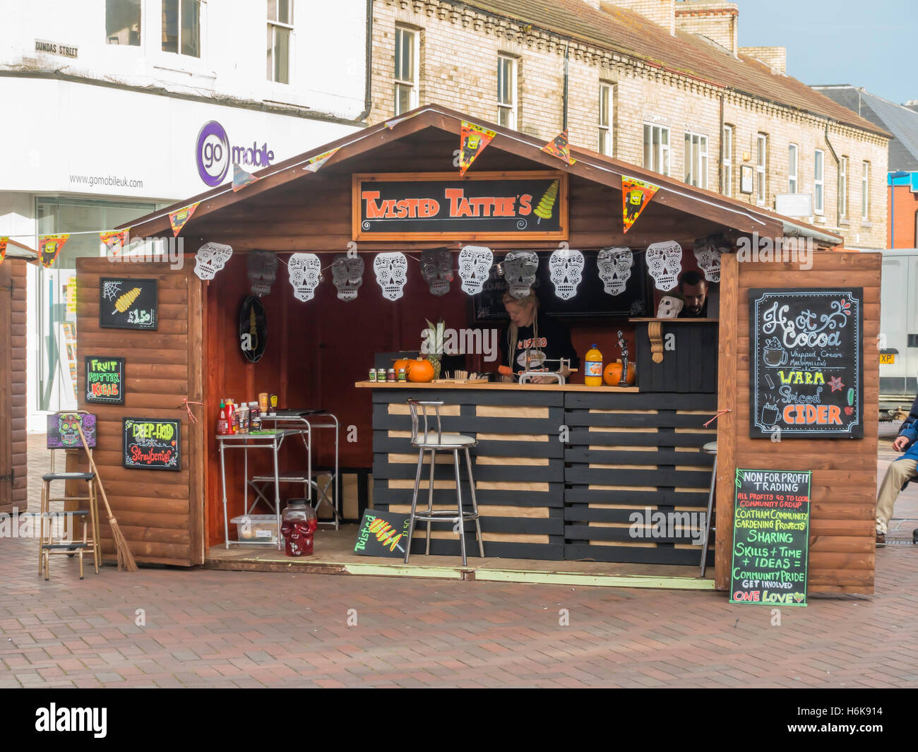 Frau Stall Inhaber verkauft verdreht Tatties Bratkartoffeln auf einem Marktstand Spezialist für Halloween in North Yorkshire Stockfoto