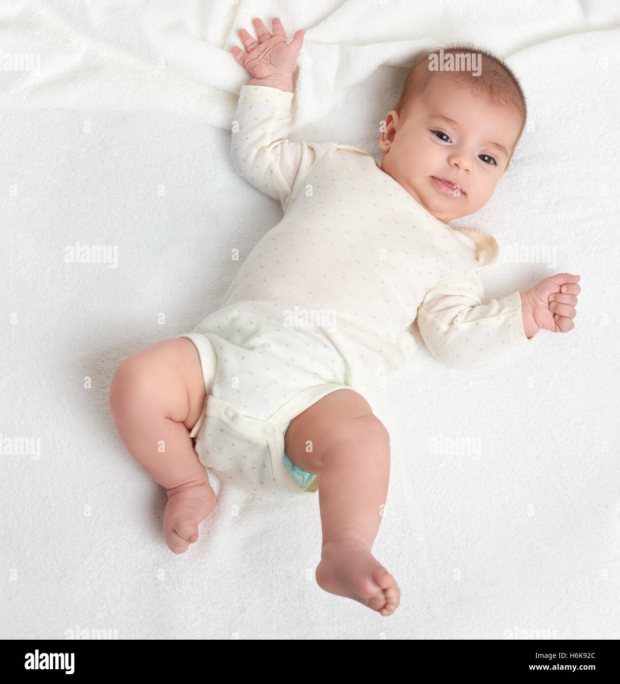 Baby-Lüge auf weißen Handtuch im Bett, Ansicht von oben Stockfoto