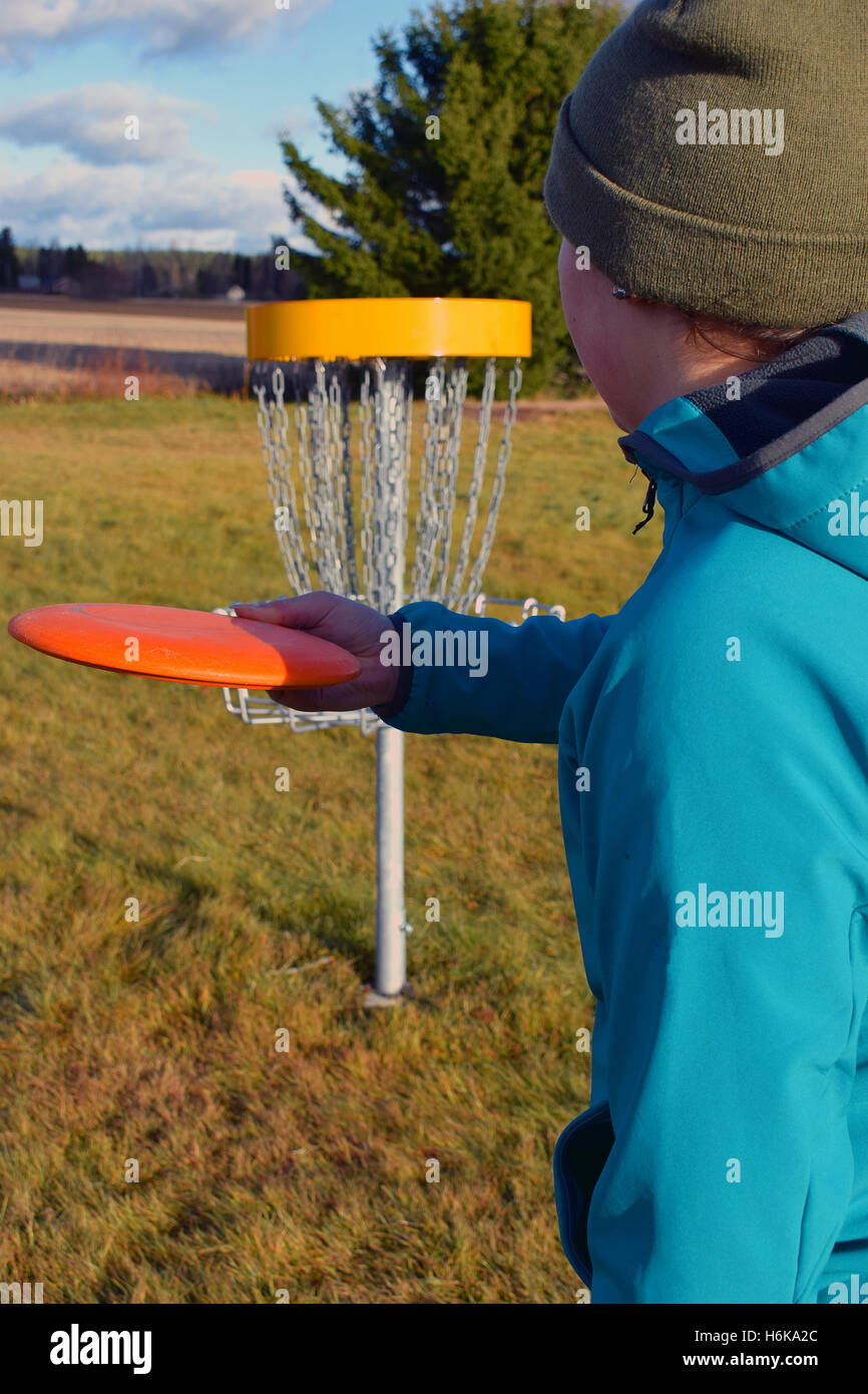 Frau mit dem Ziel Scheibe zum Ziel auf Frisbee-Golf-Kurs Stockfoto