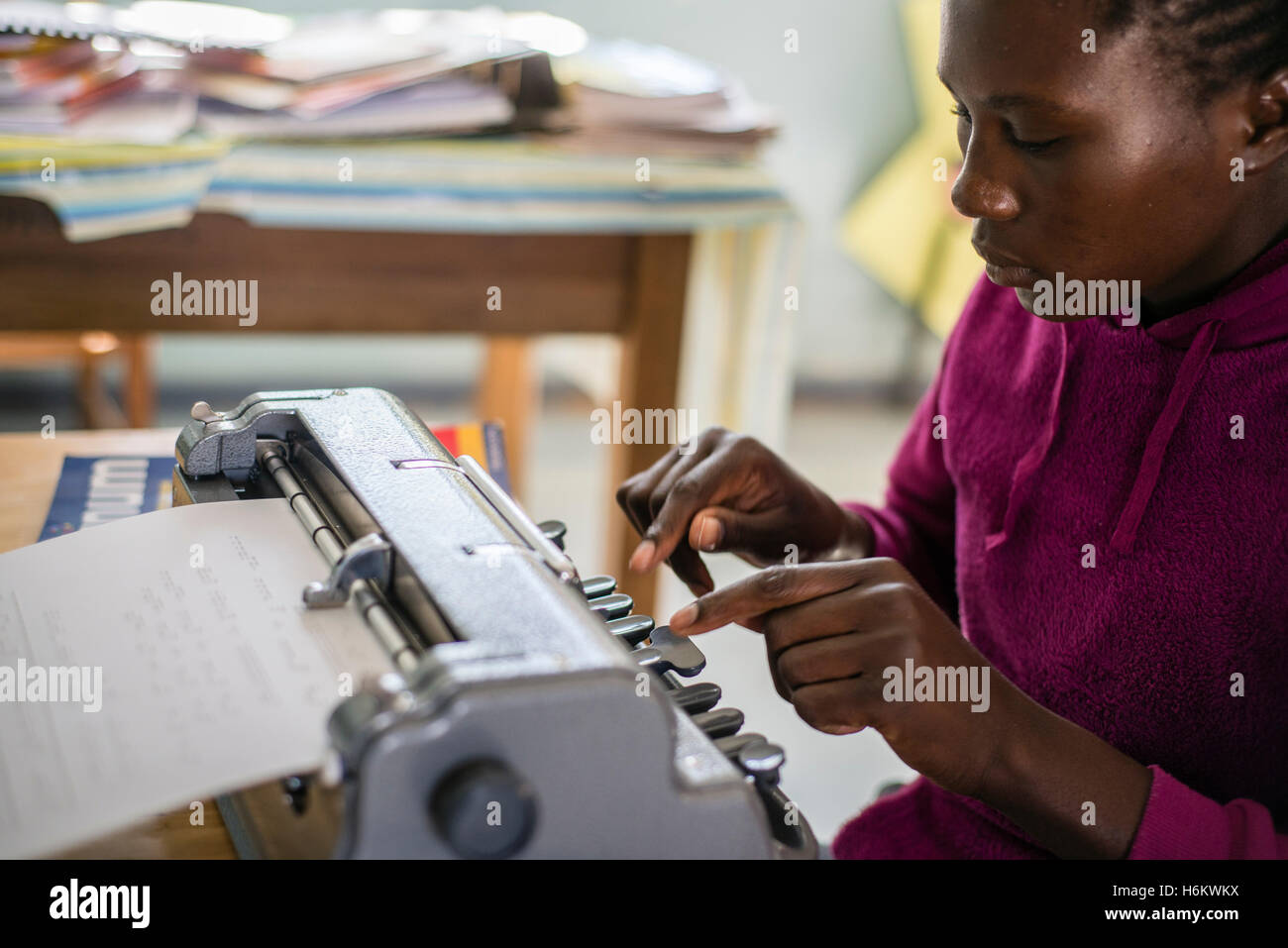 Ein Lerner der Eluwa besondere Schulbereiche auf einer Schreibmaschine während der Englischstunde. Stockfoto