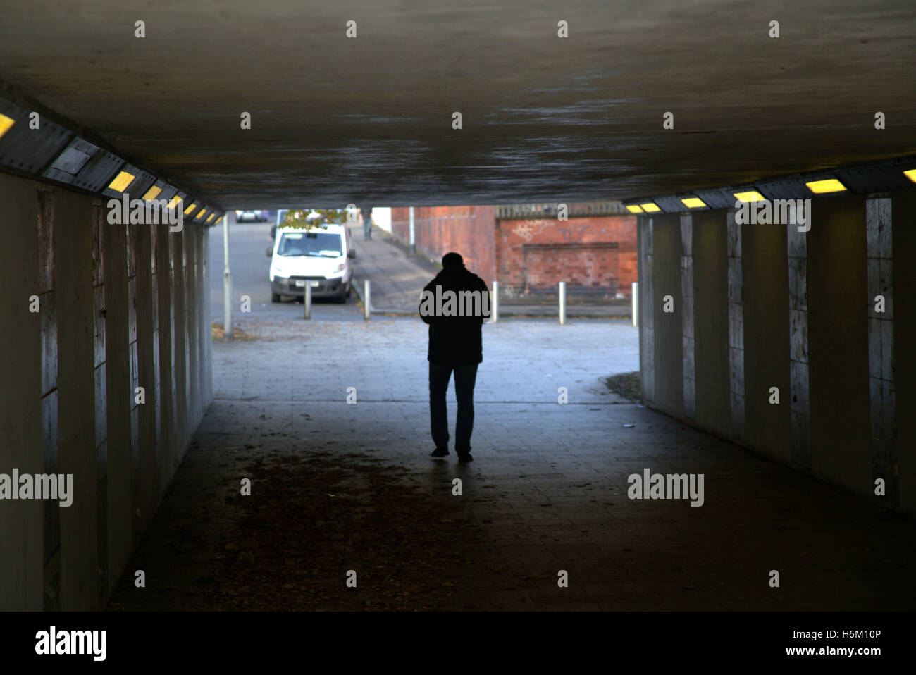 Junger Mann zu Fuß in Unterführung Stadtsilhouette Glasgow, Schottland, Großbritannien Stockfoto
