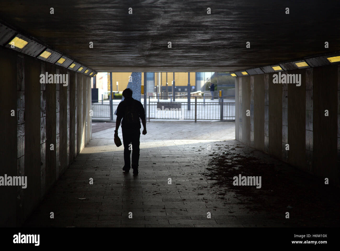 Junger Mann zu Fuß in Unterführung Stadtsilhouette Glasgow, Schottland, Großbritannien Stockfoto
