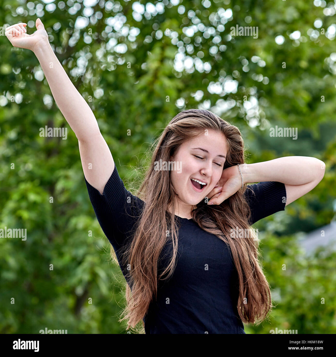 Verträumte junge Frau Gähnen und dehnen Stockfoto