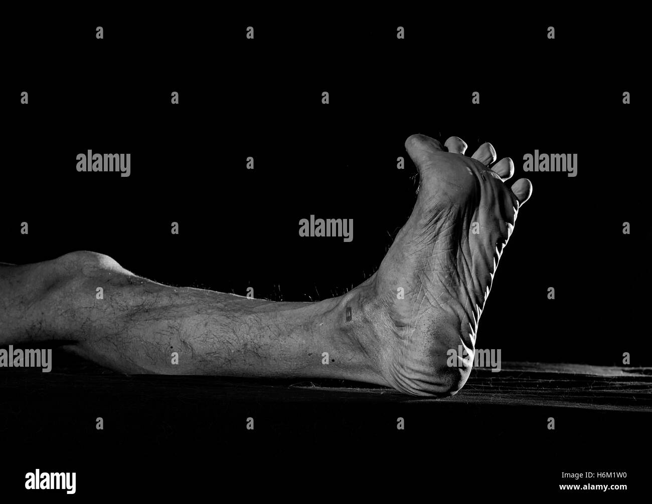 Schmutzige Fuß barfuß Männer vor einem dunklen Hintergrund. Stockfoto