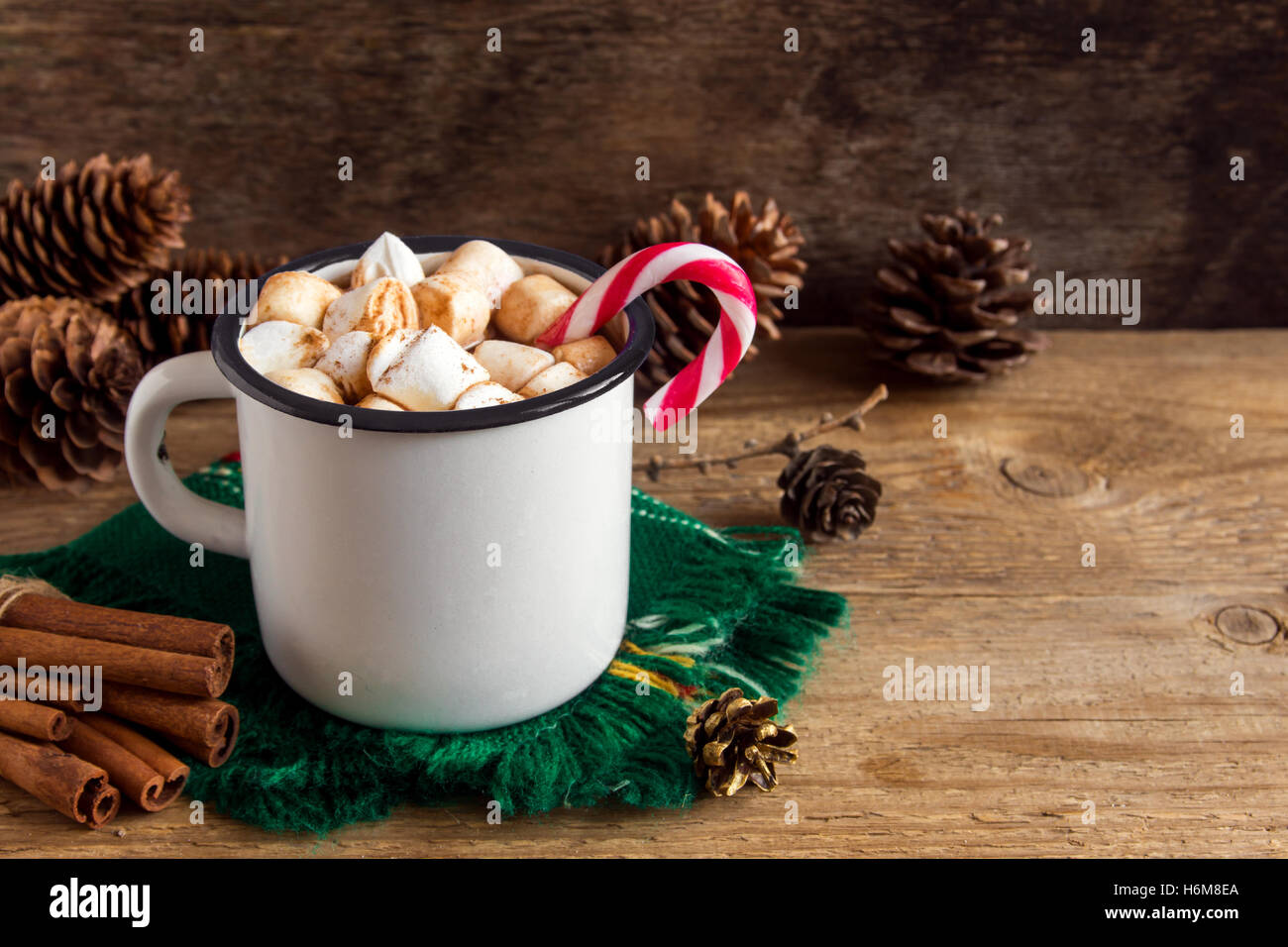 Heiße Schokolade mit Marshmallows, Pfefferminz Zuckerstangen und Zimtstangen in Vintage Metall Becher - hausgemachte festliches Heißgetränk Stockfoto