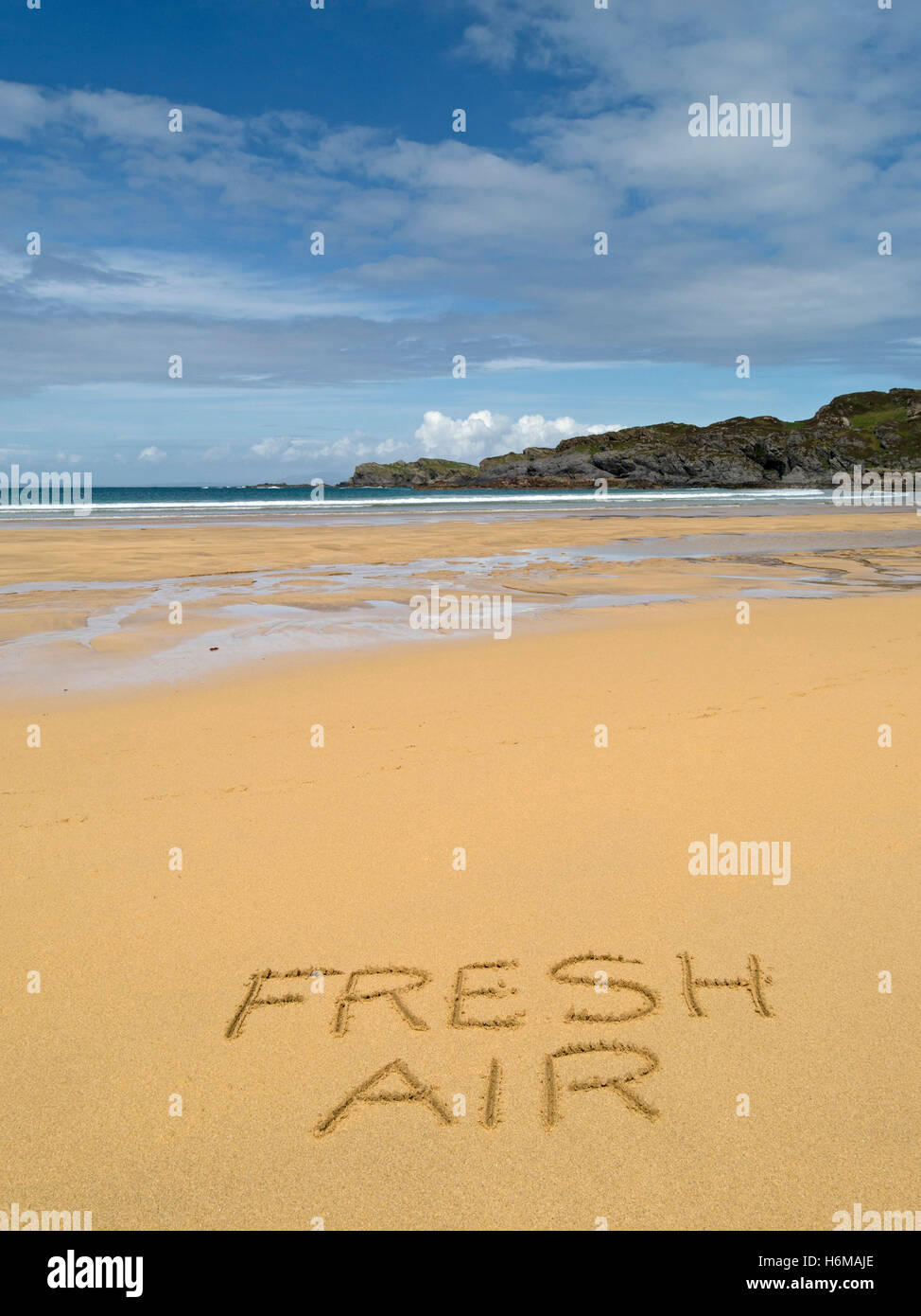 Die Worte "Frischluft" in goldenen gelben Sand der einsamen, abgelegenen abgelegenen schottischen Strand geschrieben. Stockfoto