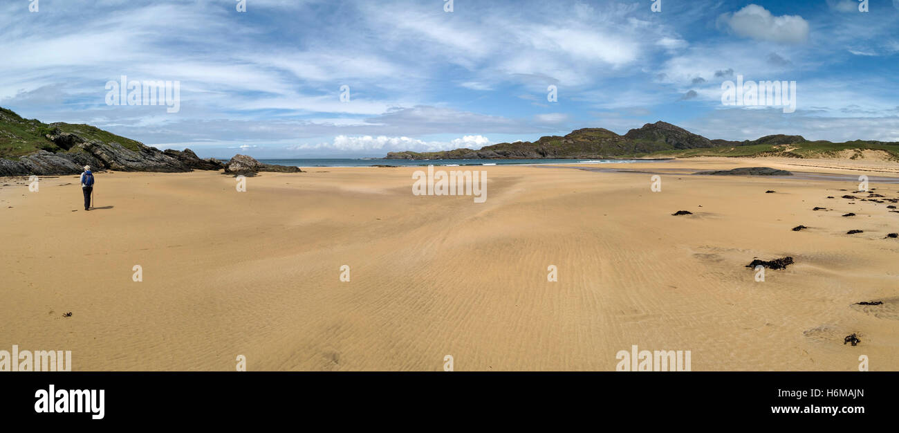 Einsame Gestalt zu Fuß am leeren Sandstrand von Kiloran Bay Beach auf der abgelegenen Hebriden Insel Colonsay, Schottland, UK. Stockfoto